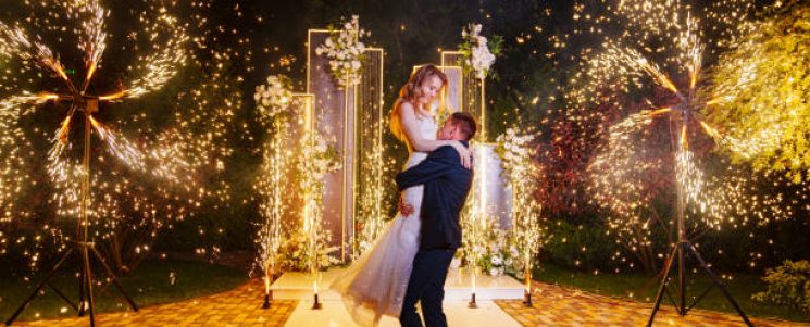 The bride and groom on wedding ceremony venue with fireworks at night. Wedding decor. professional organization of the celebration.